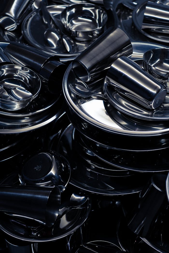 Abstract arrangement of metallic parts with shiny chrome reflections in a vertical shot.